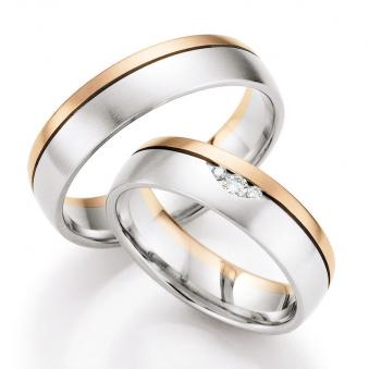 Aufnahme von Weißgold & Rotgold Trauringen längsmatt mit drei glänzenden Diamanten