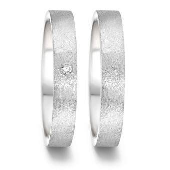 Aufnahme von schmalen Eheringen aus Edelstahl mit eismattem Design und Diamanten 