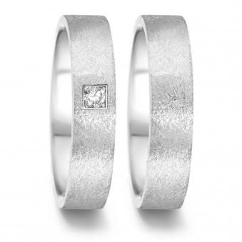 Aufnahme von Eheringen aus Edelstahl mit eismattem Design und Diamanten in Pavee-Fassung