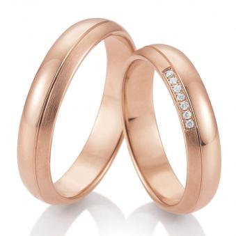  	Frontale Aufnahme von gerundeten Trauringen aus Roségold mit 7 Diamanten Polierung und Mattierung 