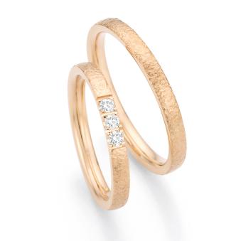 Eheringe aus Roségold mit 3 Diamanten und Hammerschlag-Oberfläche