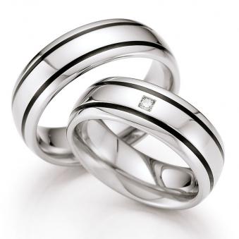  	Frontale Aufnahme von Eheringen aus Edelstahl mit zwei schwarzen Keramikstreifen und Diamant 