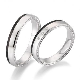 Aufnahme von polierten Eheringen aus Weißgold und Carbon mit Maserung und Diamanten