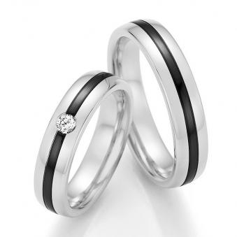 Aufnahme von Trauringen aus Weißgold mit mittigem Zirconiumstreifen und rundem weißem Diamanten 