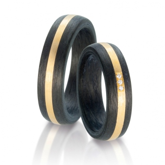 Aufnahme von Carbon Trauringen mit Gelbgold Akzentstreifen und 3 Brillanten