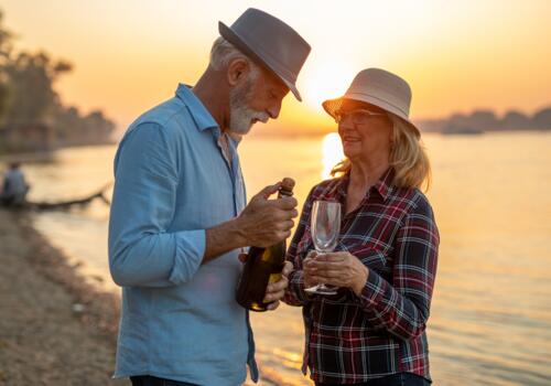 Paar öffnet Flasche am Strand